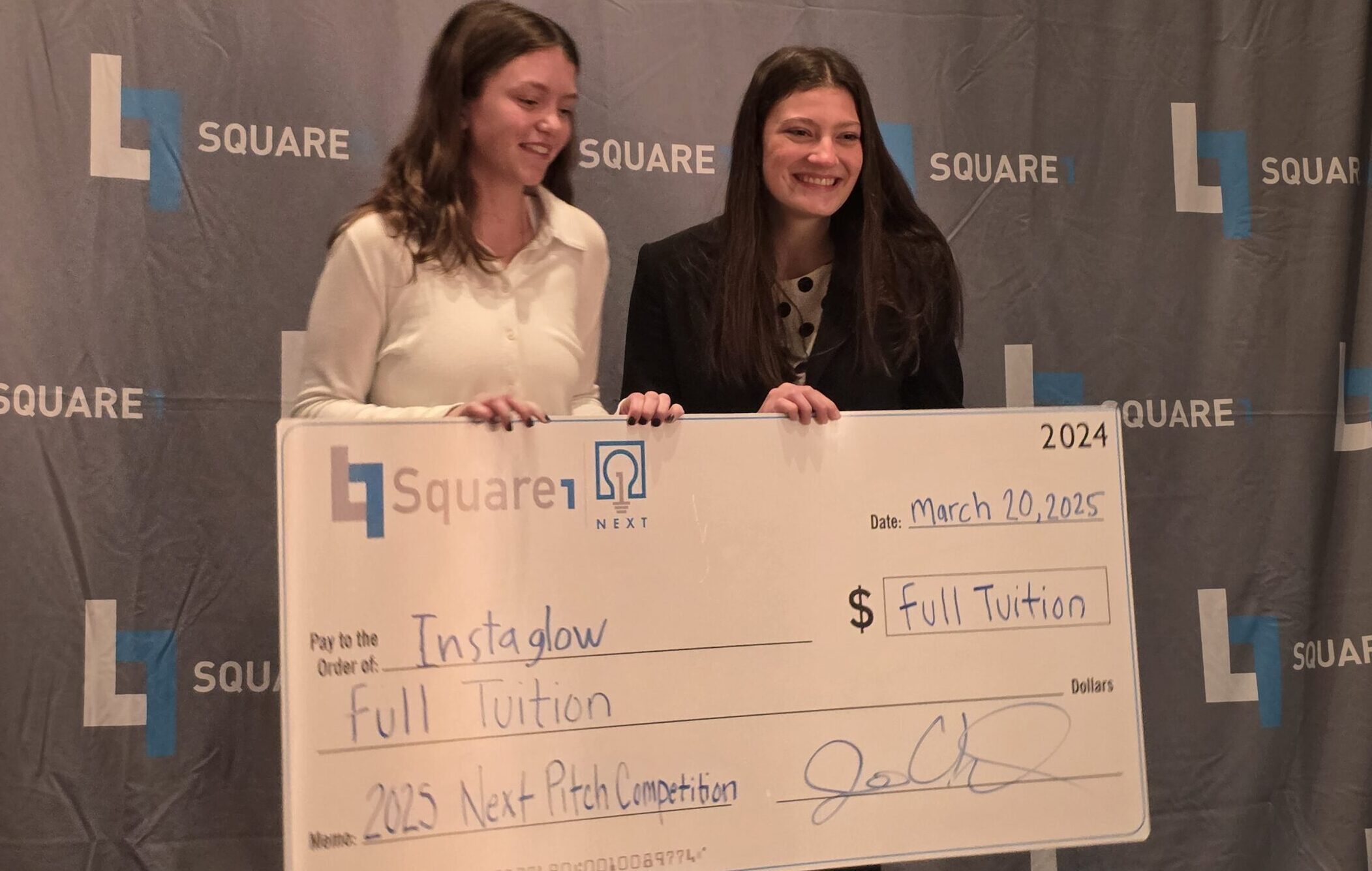 First place winners Anna Amundson & Marin Connelly pose with their full tuition check to Thomas More University.